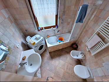Badezimmer mit Badewanne, Bidet und Waschmaschine