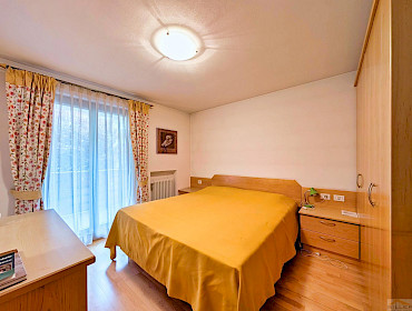 Schlafzimmer mit Doppelbett sowie Zugang zum Balkon