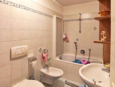 bathroom with large bathtub and washing machine connection
