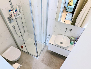 bathroom with toilet, shower cubicle, sink
