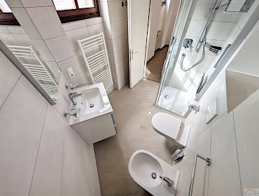 Badezimmer mit Dusche, Fenster und Waschmaschinenanschluss