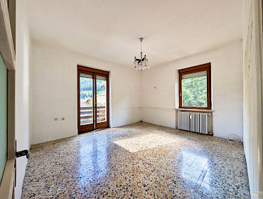helles Wohnzimmer mit Fenster und Zugang zum Balkon